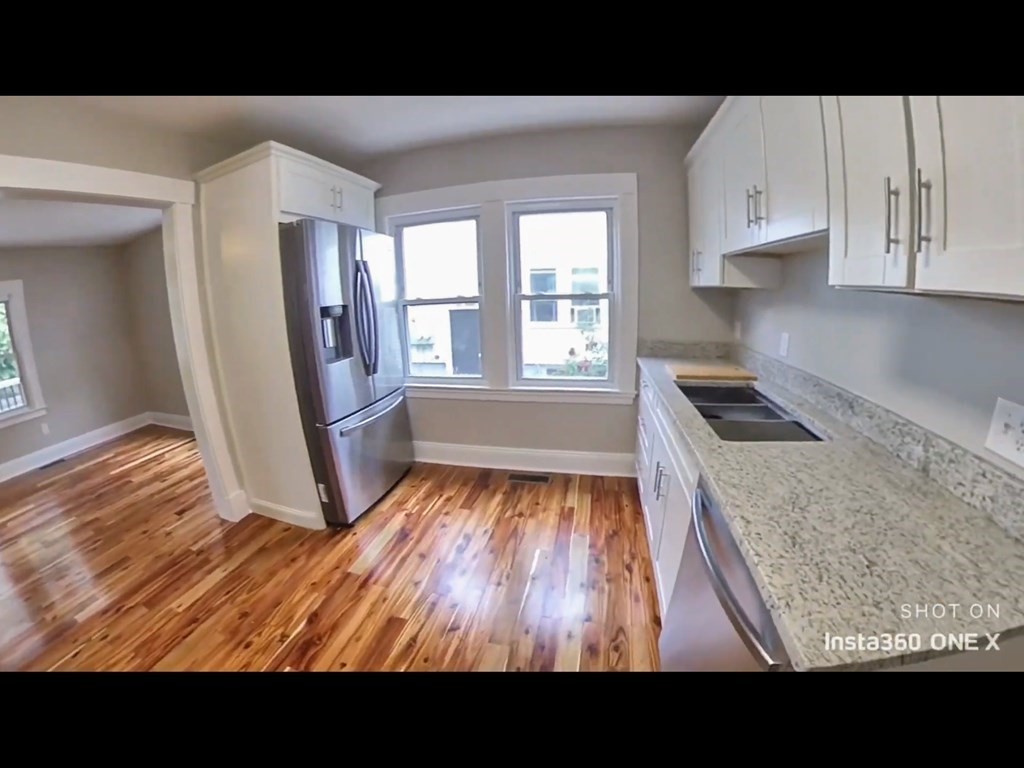 103 Lexington Street, Unit 103 Newton, MA 02466 - Photo 5 of 19 a view of an empty room with kitchen and a window