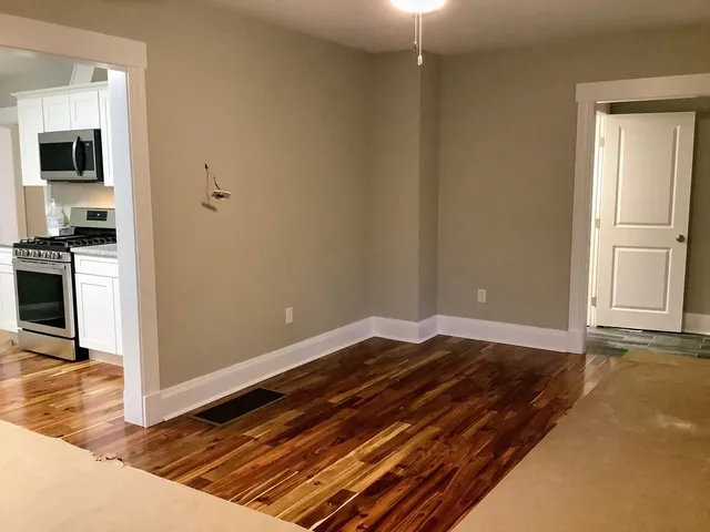 a view of a room with wooden floor and a sink
