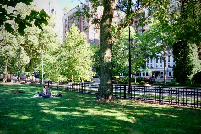 a front view of a house with lots of flowers and trees