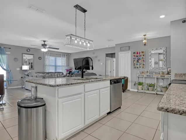 a kitchen with stainless steel appliances granite countertop a sink and a refrigerator
