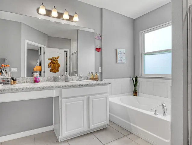 a bathroom with a tub a sink and mirror