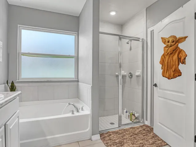 a bathroom with a tub a window and a shower