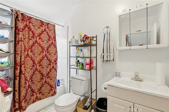 a bathroom with a toilet sink and shower curtain