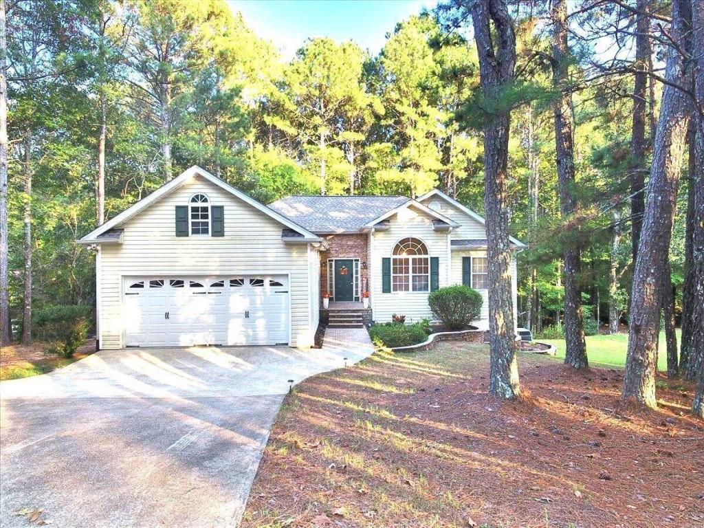 2694 Pleasant Grove Church Road Villa Rica, GA 30180 - Photo 1 of 1 a view of a white house with a yard and large trees
