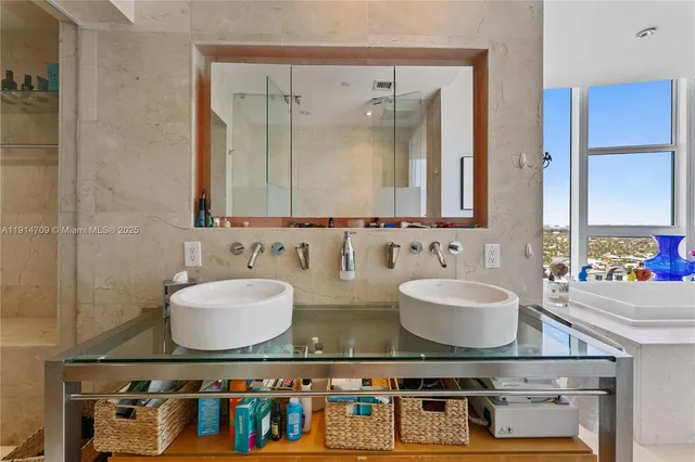a bathroom with double vanity sinks a mirror and a shower