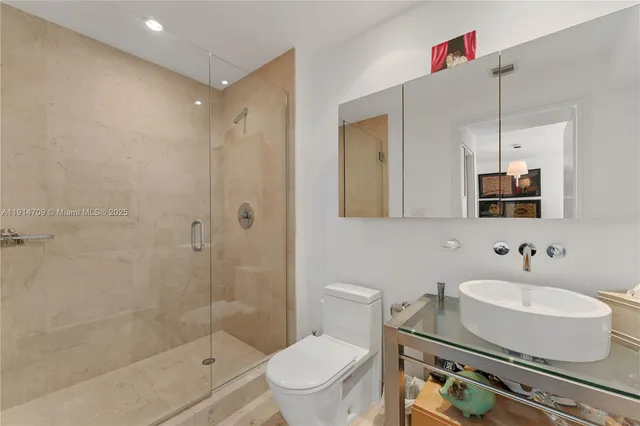 a bathroom with a sink toilet a mirror and shower