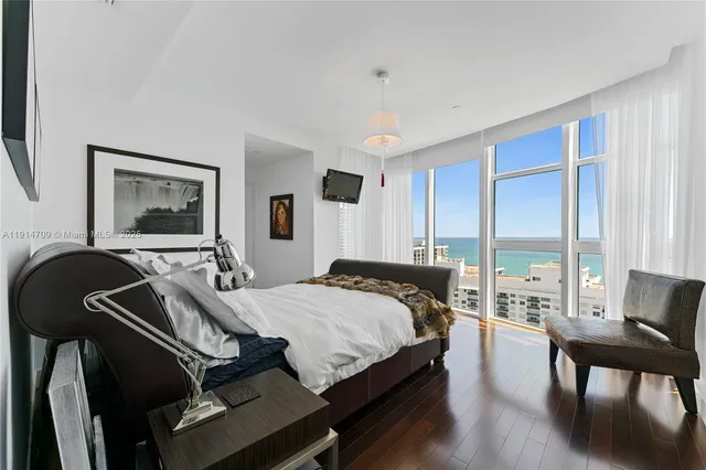 a bedroom with a bed a desk and chair with the outer view