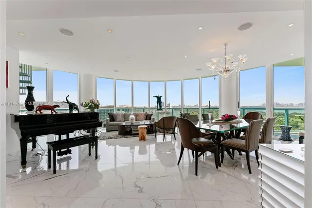 a living room with lots of chairs and kitchen view