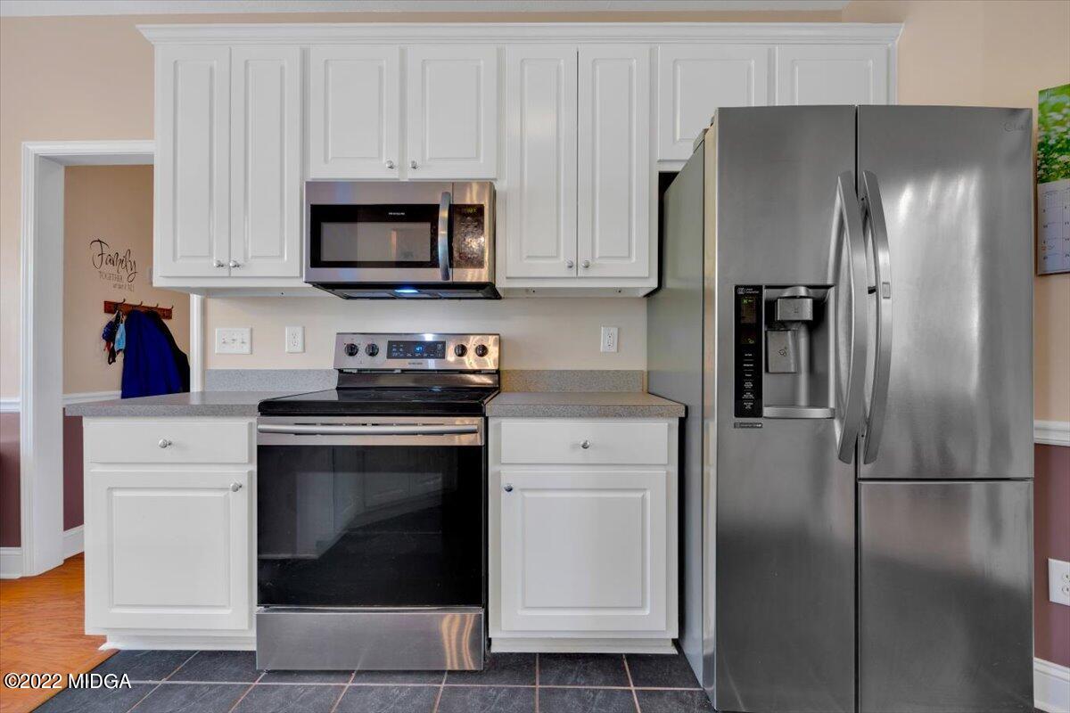 1360 Patterson Road Griffin, GA 30223 - Photo 13 of 24 a kitchen with stainless steel appliances white cabinets and a refrigerator