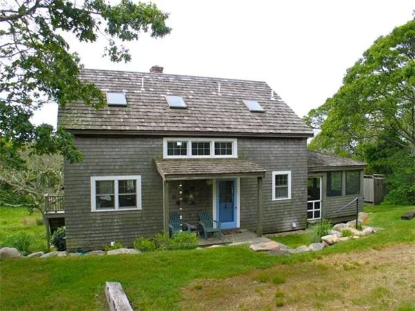 a front view of a house with a yard and trees