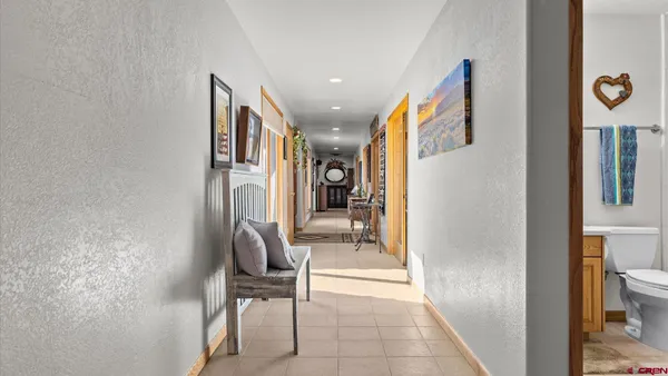 a view of hallway with furniture and a bathroom