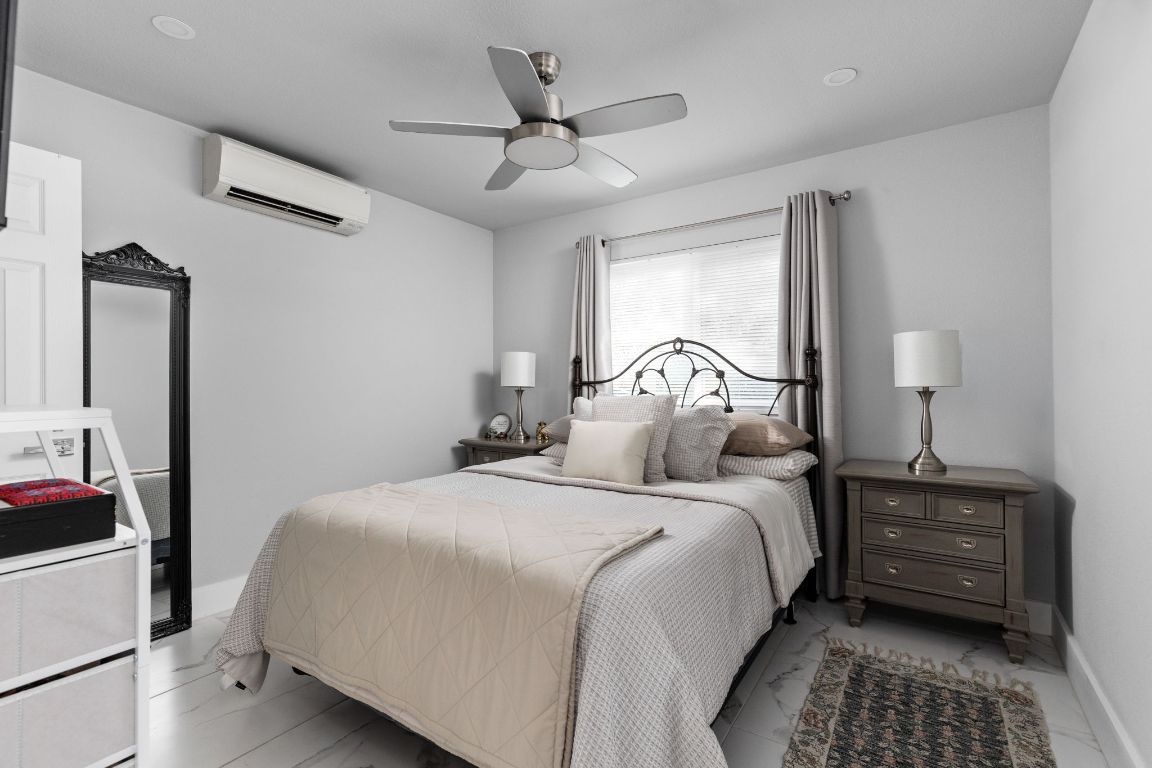 3308 Bengston Street Austin, TX 78702 - Photo 17 of 25 a bedroom with a bed a chandelier and a dresser