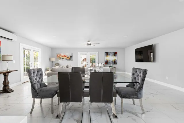 a bedroom with a bed a chandelier and a dresser