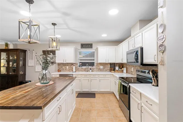 a kitchen with stainless steel appliances granite countertop a sink dishwasher stove refrigerator and cabinets
