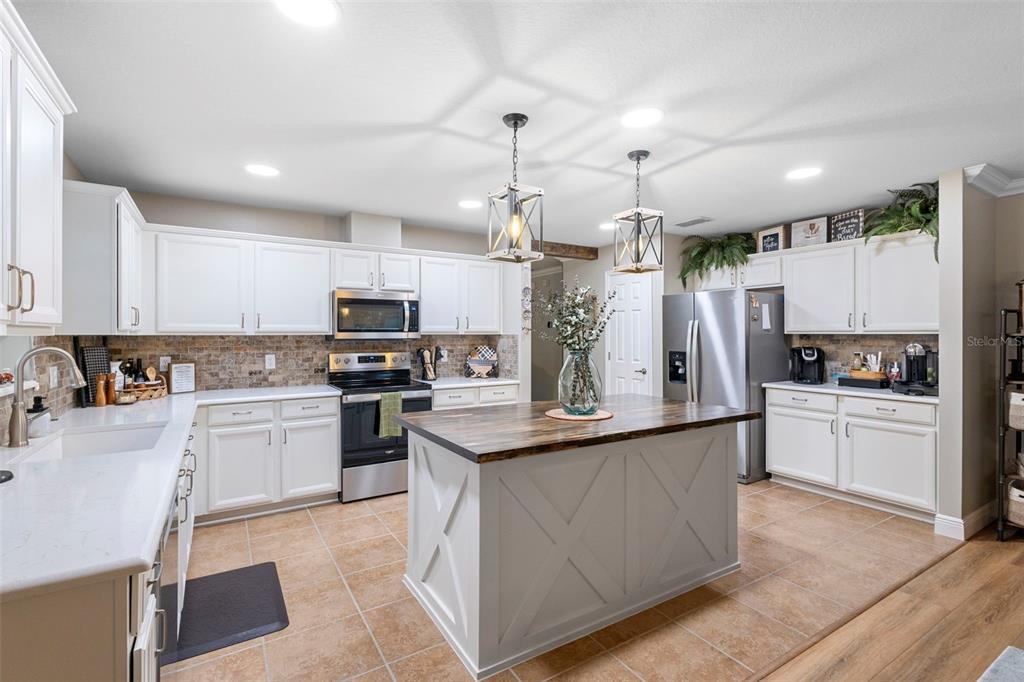 30118 Cheval Street Mount Dora, FL 32757 - Photo 17 of 52 a kitchen with kitchen island granite countertop a sink cabinets and stainless steel appliances