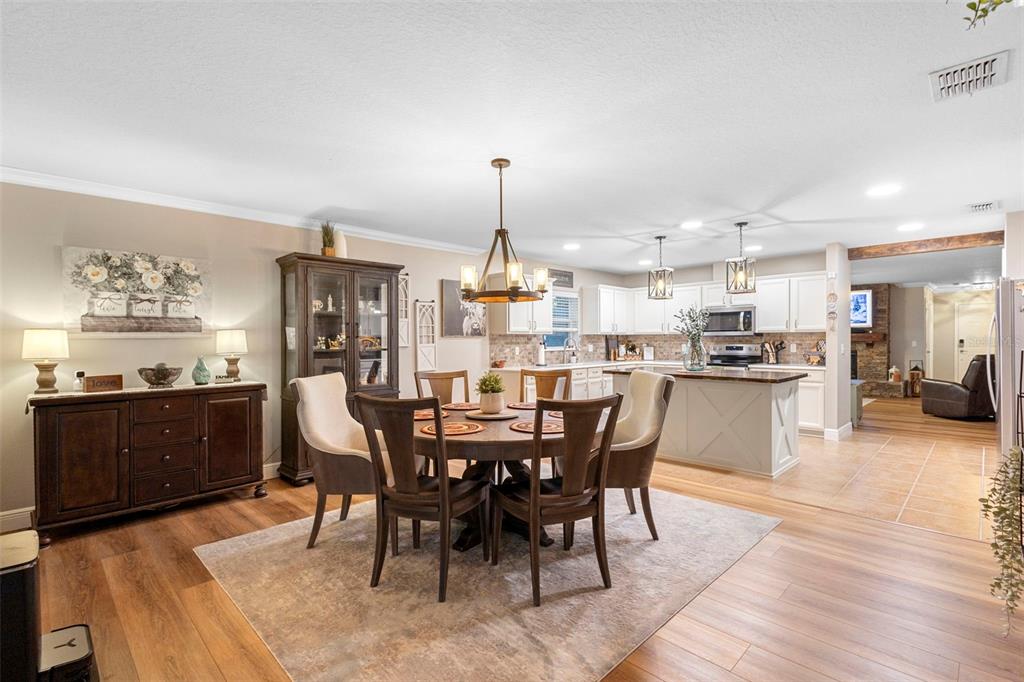 30118 Cheval Street Mount Dora, FL 32757 - Photo 22 of 52 a dining room with stainless steel appliances kitchen island granite countertop a table chairs and a view of living room