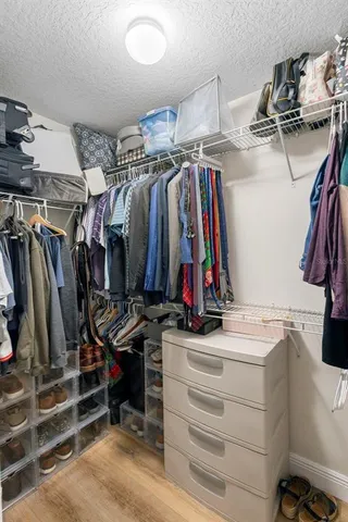a view of walk in closet with clothes and shoes