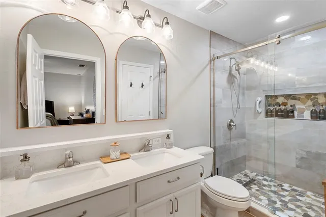 a bathroom with a sink a toilet and shower