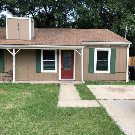 a front view of a house with a garden and yard