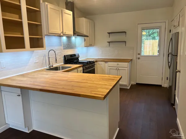 a kitchen with stainless steel appliances granite countertop a sink stove and cabinets