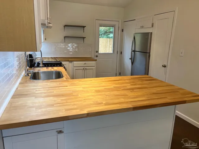 a bathroom with a sink a mirror and a refrigerator