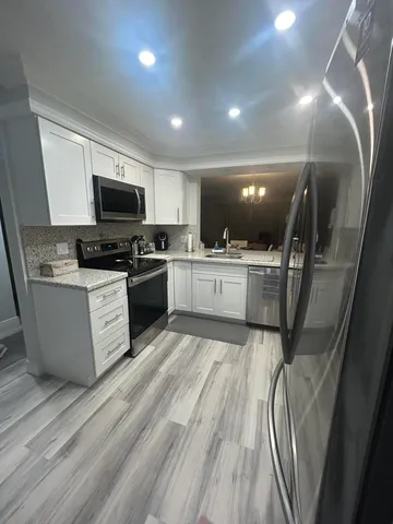 a kitchen with a sink stainless steel appliances a counter top space and cabinets