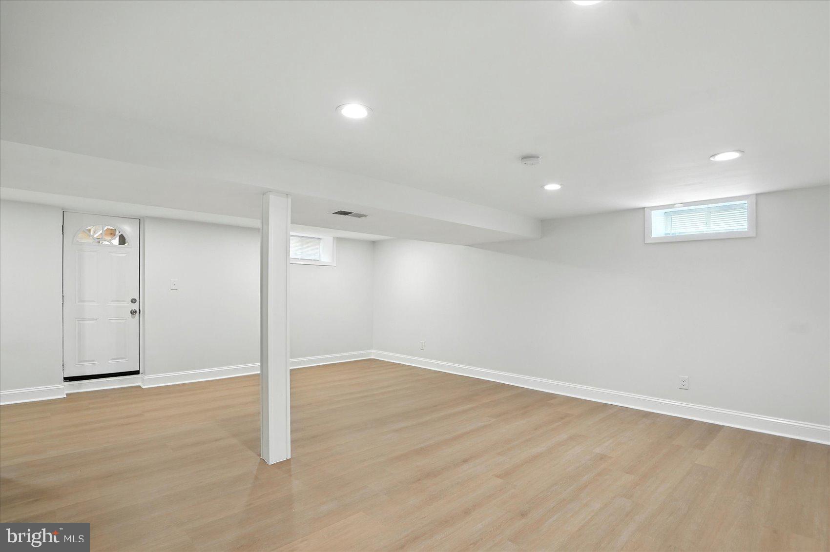 7031 Glen Spring Road Baltimore, MD 21244 - Photo 32 of 43 an empty room with wooden floor and windows