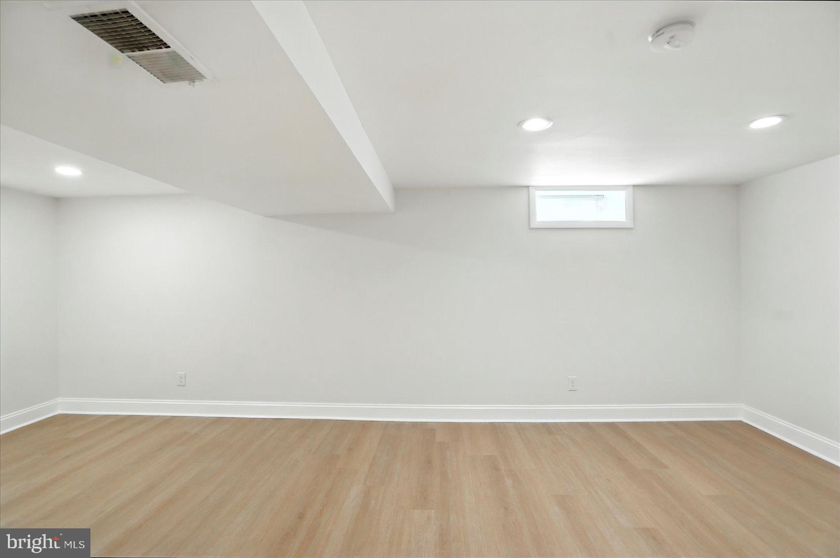 7031 Glen Spring Road Baltimore, MD 21244 - Photo 38 of 43 an empty room with wooden floor and windows