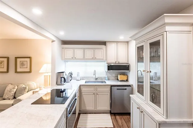 a kitchen with stainless steel appliances granite countertop a refrigerator and a stove top oven