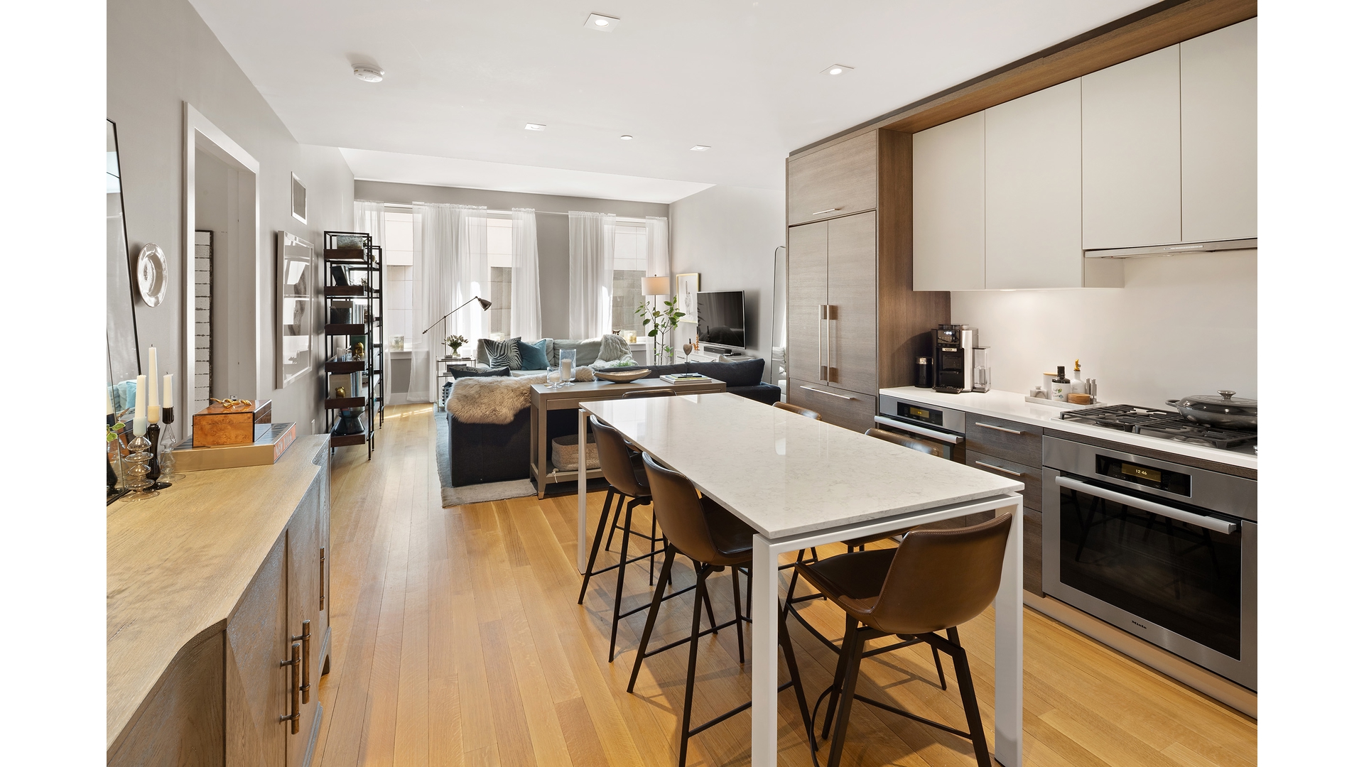 101 Leonard Street, Unit 5F Manhattan, NY 10013 - Photo 2 of 9 a open kitchen with stainless steel appliances granite countertop a stove a refrigerator a sink dishwasher and white cabinets with wooden floor
