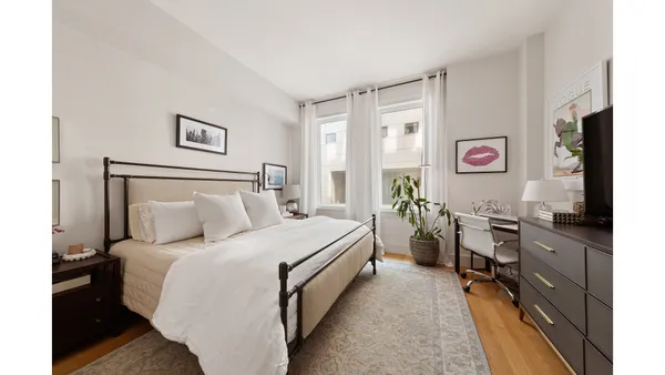 a bed room with a bed tv and a window