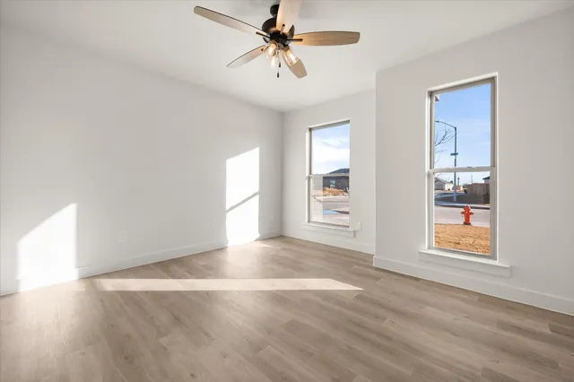 an empty room with windows and fan