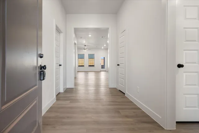 a view of a hallway with wooden floor