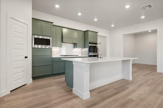 a kitchen with white cabinets and stainless steel appliances