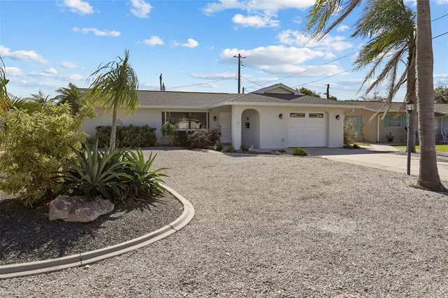 a view of a house with a yard and potted plants