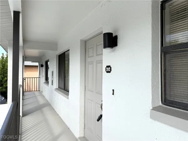 a view of a hallway with wooden floor and windows