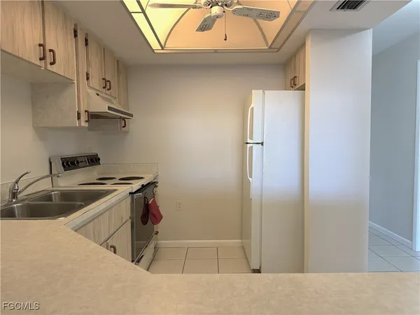 a kitchen with stainless steel appliances granite countertop a sink and a refrigerator