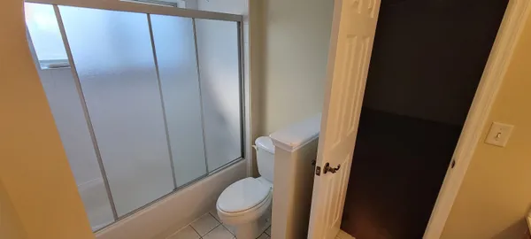 a white toilet sitting next to a shower