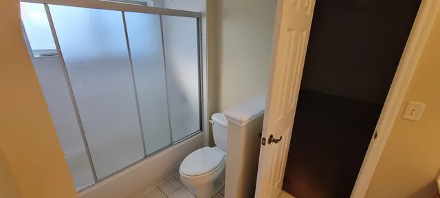 a white toilet sitting next to a shower