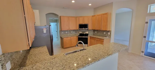 a kitchen with stainless steel appliances granite countertop a refrigerator stove and sink