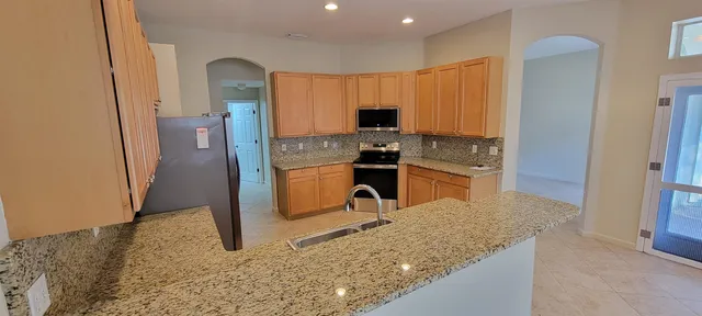 a kitchen with stainless steel appliances granite countertop a refrigerator stove and sink