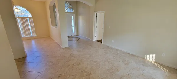 a view of an empty room with entrance and a livingroom