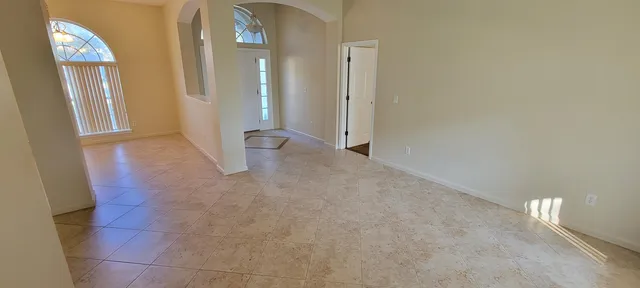 a view of an empty room with entrance and a livingroom