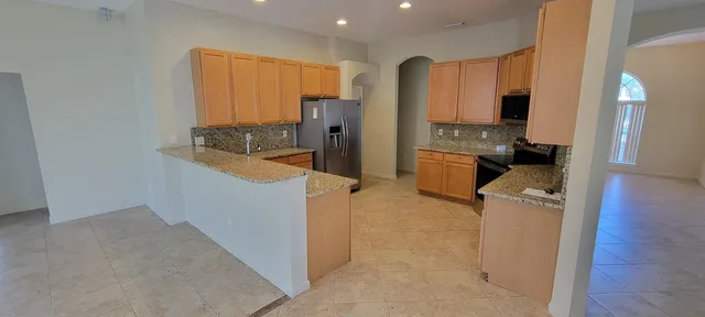 a kitchen with a refrigerator and a stove top oven