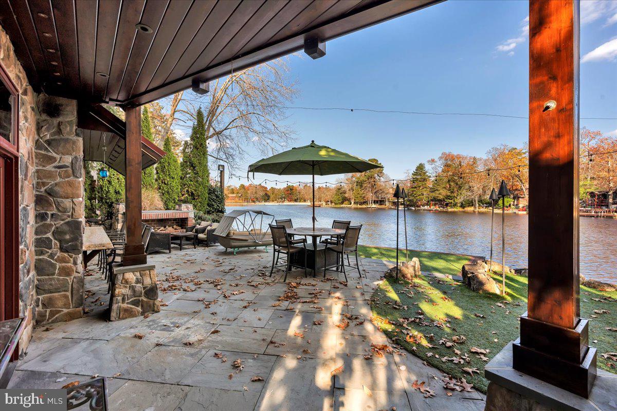 133 Stokes Road Medford Lakes, NJ 08055 - Photo 3 of 57 a view of a patio with table and chairs under an umbrella with a small yard
