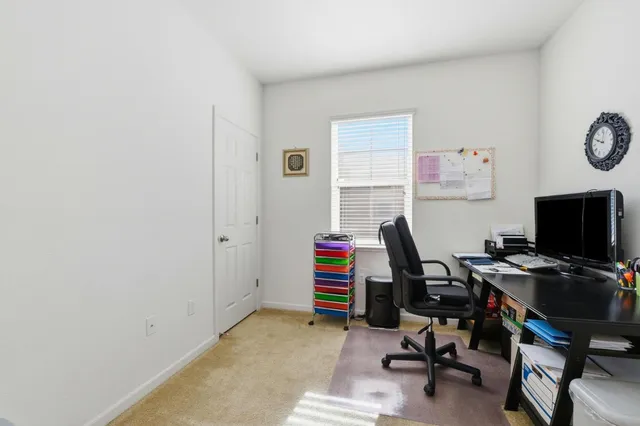 a view of a workspace with furniture and a window