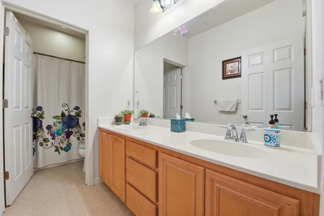 a bathroom with a double vanity sink a mirror and a shower