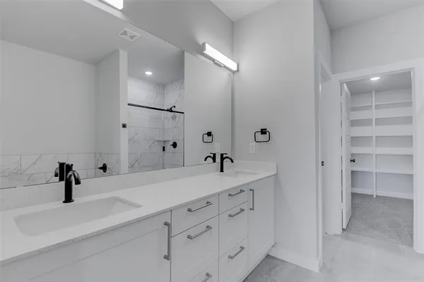 a spacious bathroom with a double vanity sink mirror and shower