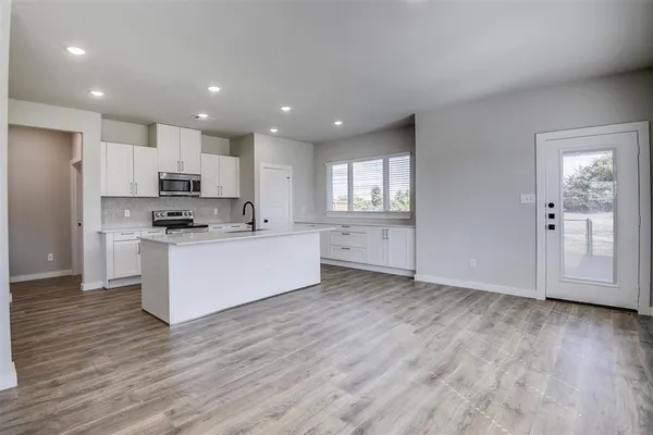 a view of kitchen with granite countertop cabinets and wooden floor