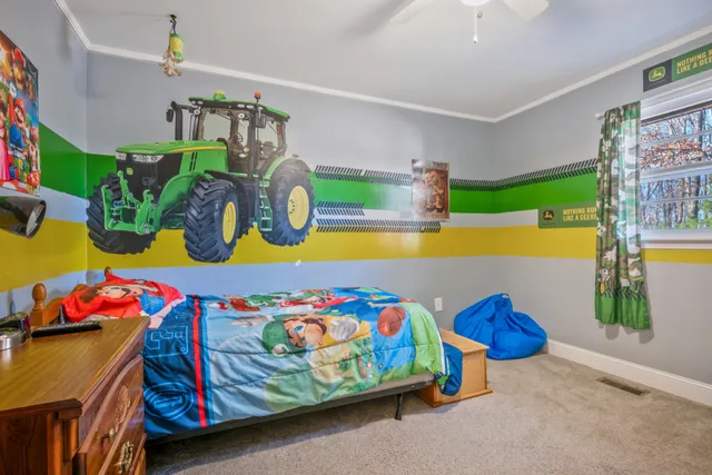 a bedroom with a bed a window and dresser